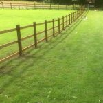 Post and rail fencing in a empty field in Birmingham.