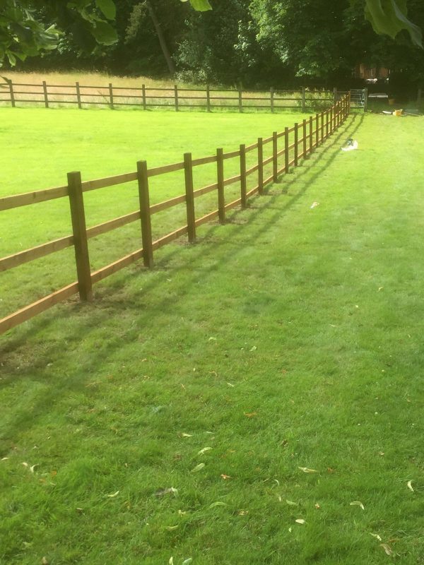 Post and rail fencing in a empty field in Birmingham.
