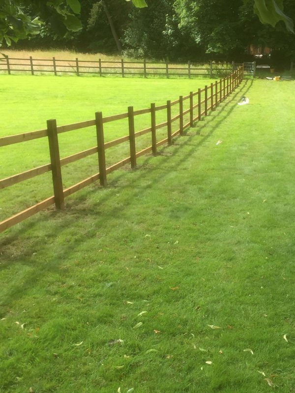 Post and rail fencing in a empty field in Birmingham.