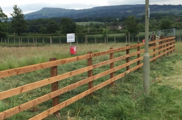 Post and rail fencing used for commercial purposes. Fencing stands alone in a empty field in Birmingham.