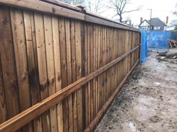 Wooden fencing being assembled in a building area. The paling fencing is perfect for securing the new properties being built.