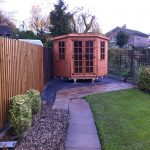 Made to measure garden shed standing in a long garden. This bespoke shed is hexagonal in shape.