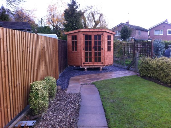 Made to measure garden shed standing in a long garden. This bespoke shed is hexagonal in shape.