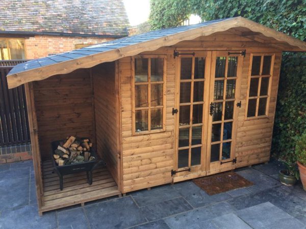 Made to measure garden shed standing in a yard beside a wall of ivory. This bespoke shed has glass windows and doors.