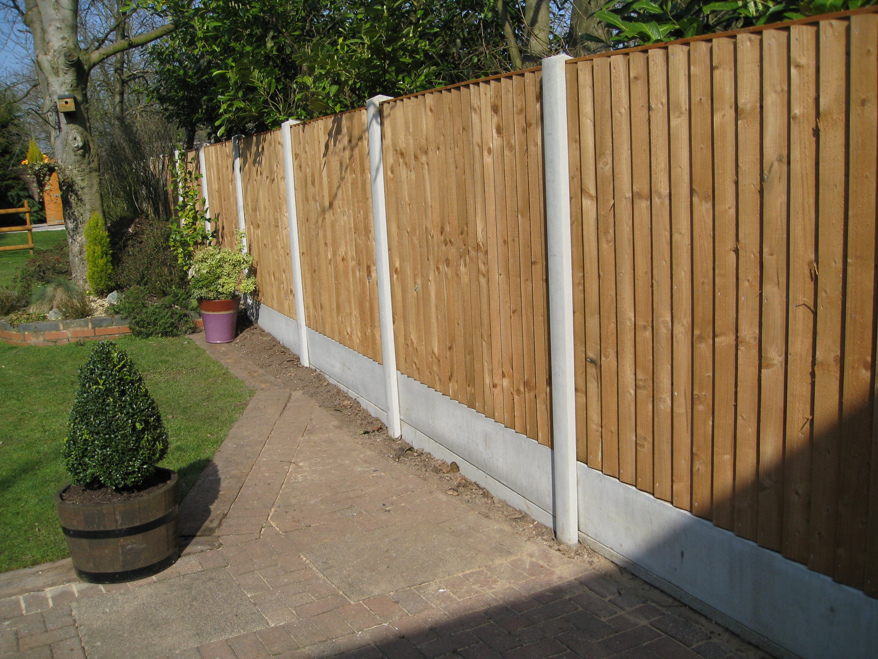 A garden in Birmingham surrounded by a fence. Fence panels are wooden with concrete posts in between.