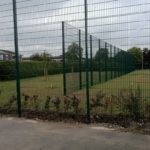 Green commercial fencing surrounding a sporting arena.