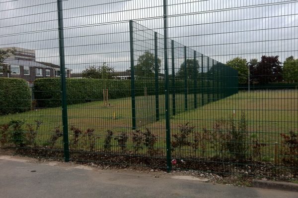 Green commercial fencing surrounding a sporting arena.