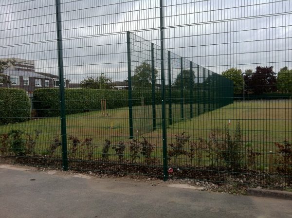 Green commercial fencing surrounding a sporting arena.