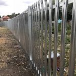 Steel commercial fencing surrounding deserted area. The steel commercial fencing is perfect for security purposes.