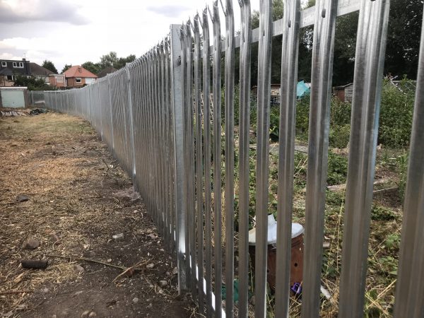 Steel commercial fencing surrounding deserted area. The steel commercial fencing is perfect for security purposes.