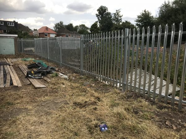 Steel paling commercial fencing surrounding a empty field.