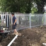 Steel commercial fencing being installed by three Hodges & Lawrence staff members in an outdoor space in Birmingham.