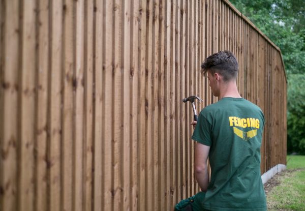 A Hodges & Lawrence staff member assembling a wooden fence in Birmingham.