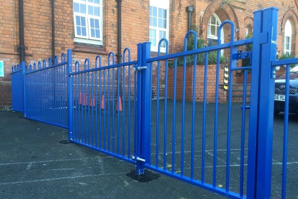 A blue steel commercial gate on a school yard in Birmingham.