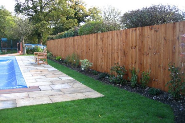 A garden in Birmingham with a pool. The garden is surrounded by a wooden feather edged fence.