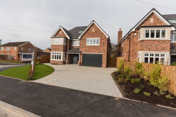 A new build house with paling fencing alongside.