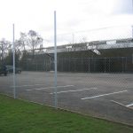 Chan link fencing. The commercial fence surrounds a car park containing two parked cars.