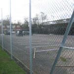 Chain linking fence surrounding a car park. This commercial fence provides security to the cars inside.