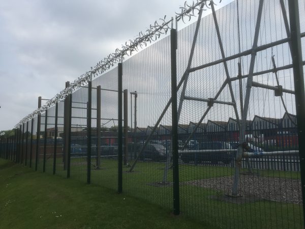 Green double mesh fencing with security spikes. This commercial fencing solution is perfect for security purposes.