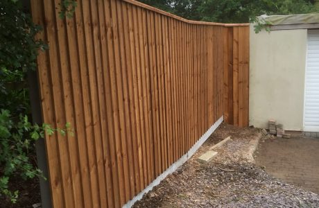 Wooden fence with feather edge fence capping.