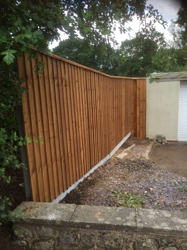 Wooden fence with feather edge fence capping.