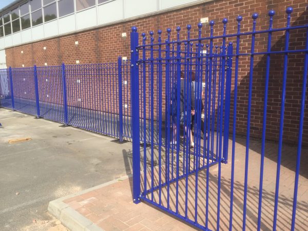 Blue bespoke railings surrounds a commercial area.