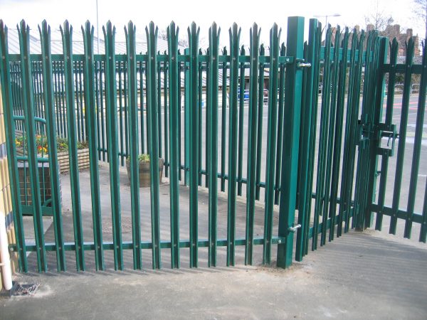 Green steel palisade fencing providing security for a commercial buildings in Birmingham.