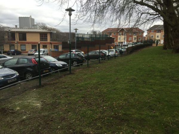 Double mesh fencing surrounding a car park. Commercial fencing provides security for different properties and areas.