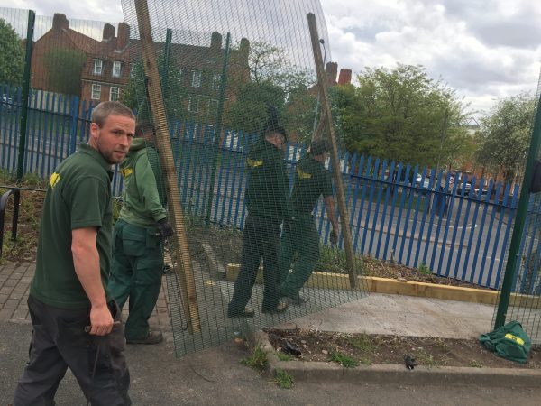 Hodges & Lawrence staff assembling double mesh fencing. This commercial fencing is great for securing sporting grounds.