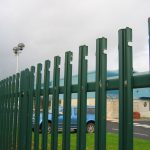 Green steel palisade fencing. This commercial fence is providing security for cars inside a car park.