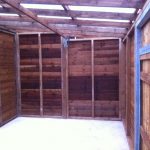 Inside of a commercial shed. The shed is wooden with a blue rope hanging from a roofing panel.