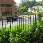 Black bespoke railings outside of a large house.