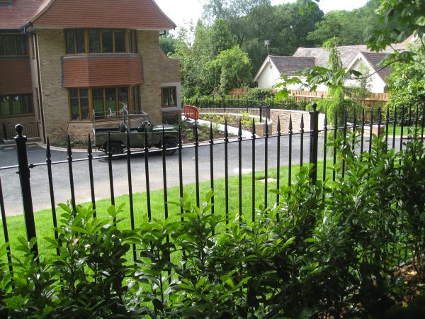 Black bespoke railings outside of a large house.