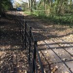 Black bespoke railings alongside a public walkway.