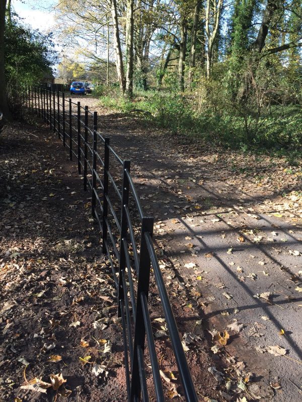 Black bespoke railings alongside a public walkway.