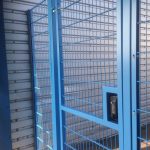 Blue double wire mesh gates, closed with secure locking system. These commercial gates are great at securing industrial areas