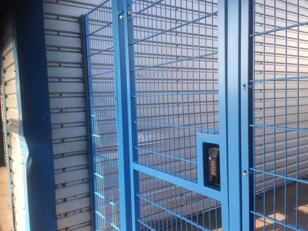 Blue double wire mesh gates, closed with secure locking system. These commercial gates are great at securing industrial areas