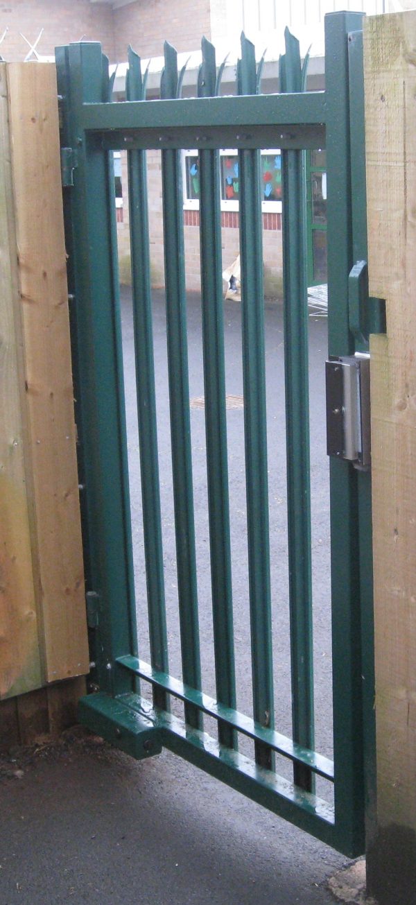 Green steel palisade gate securing a school yard.