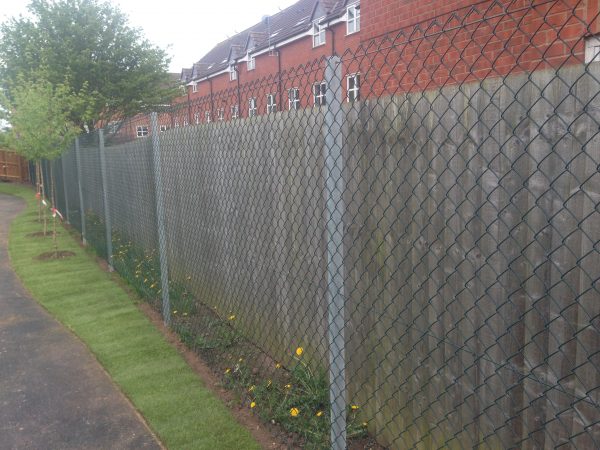 Chain link fencing alongside a public walk way. Commercial fencing provides quality security.