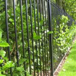 Black bespoke railings surrounding a large garden. Bespoke railings provide security whilst looking aesthetically pleasing.