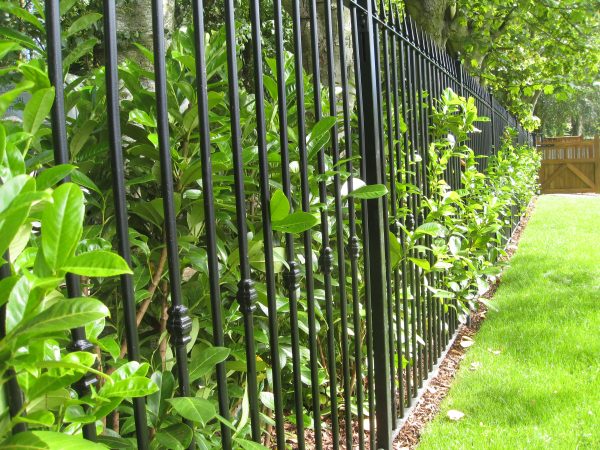 Black bespoke railings surrounding a large garden. Bespoke railings provide security whilst looking aesthetically pleasing.