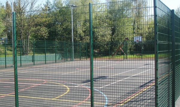 Multiple use games area in a school are park yard. Sport area fit with goal posts and basketball nets.