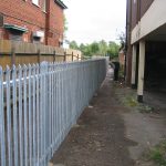 Steel palisade fencing is being assembled by Hodges & Lawrence staff. Commercial fencing provides quality security.