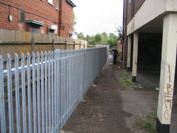 Steel palisade fencing is being assembled by Hodges & Lawrence staff. Commercial fencing provides quality security.