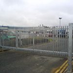 Steel palisade gates gate securing large vehicles in yard. These commercial gates are great for securing industrial spaces.