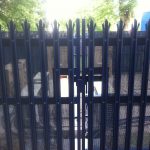 Blue steel palisade gates. These secure commercial gates keep electrical goods safe.