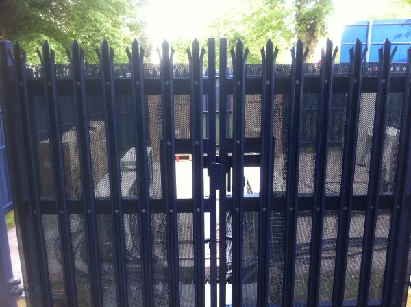 Blue steel palisade gates. These secure commercial gates keep electrical goods safe.