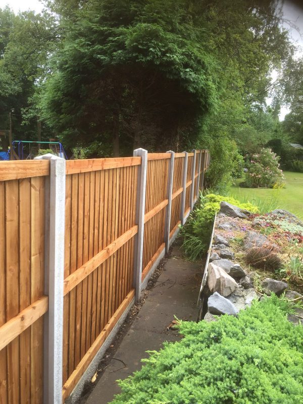 A long wooden fence in a garden in Birmingham. The fence has close board fence panels.