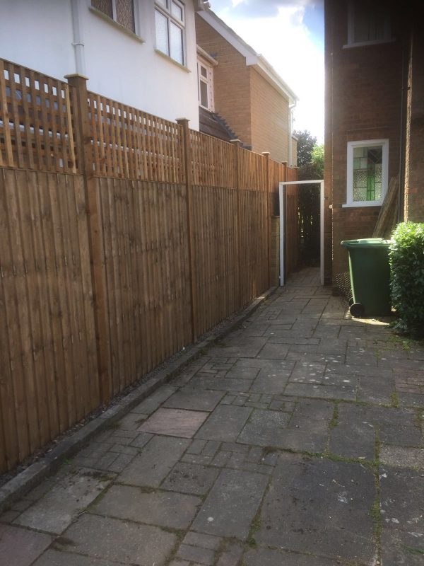 A wooden fence alongside a house in Birmingham. It is a v type fence with close board fence panels.