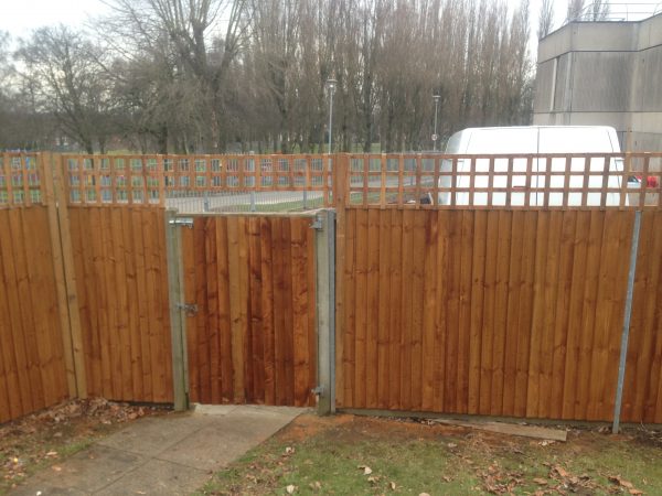 Tall wooden fence. The fence has t type timber trellis fencing panels.